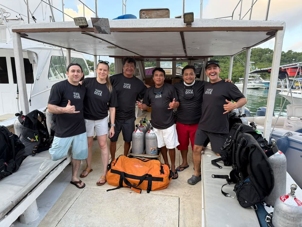 The Cozumel Top Dive Experience team in branded shirts on the boat at the dock